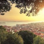 Photo de la ville de Lisbonne avec un couché de soleil et une vue sur la ville et l'ocean