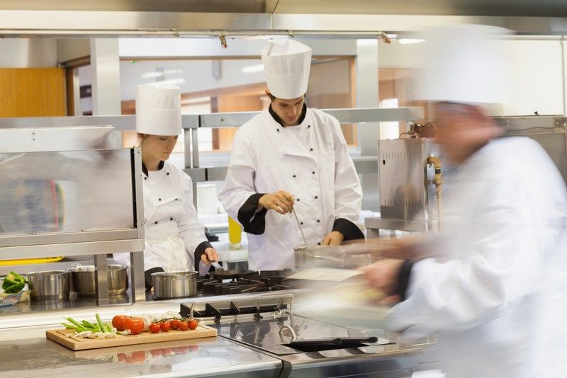 Brigade de cuisine préparant des plats dans les cuisines d'un restaurant